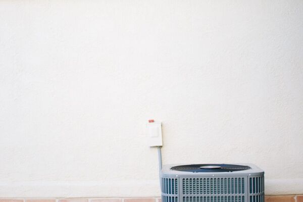 Residential air conditioning condenser with a Milwaukee Packout tool bag, serviced by Five Star in St. George, Utah