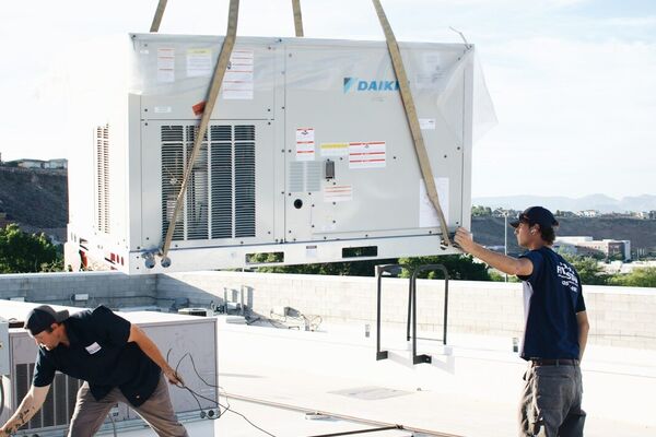 Five Star team using a crane to set a new Daikin rooftop package unit during a commercial installation in St. George, Utah