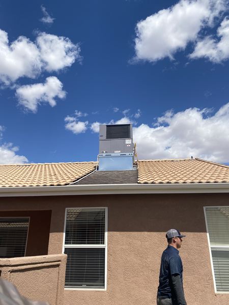 Five Star tech walking past a freshly installed Carrier rooftop package unit