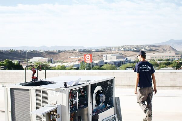 Five Star technician on a commercial rooftop with the St. George skyline behind during an HVAC service call
