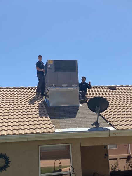 Two Five Star techs on a tile roof after a Carrier package unit install